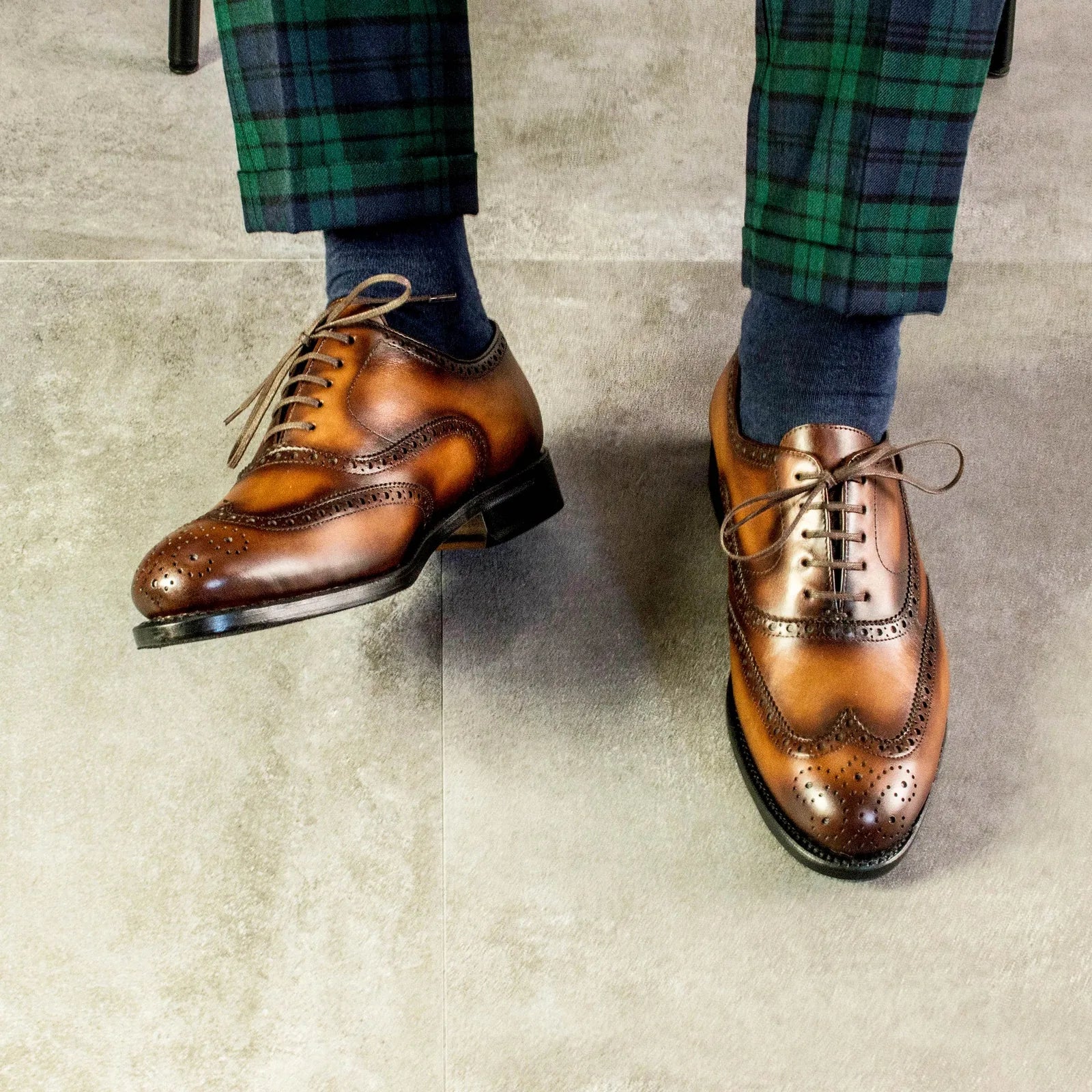 Blackwatch tartan trousers with a wingtip shoe, worn perspective